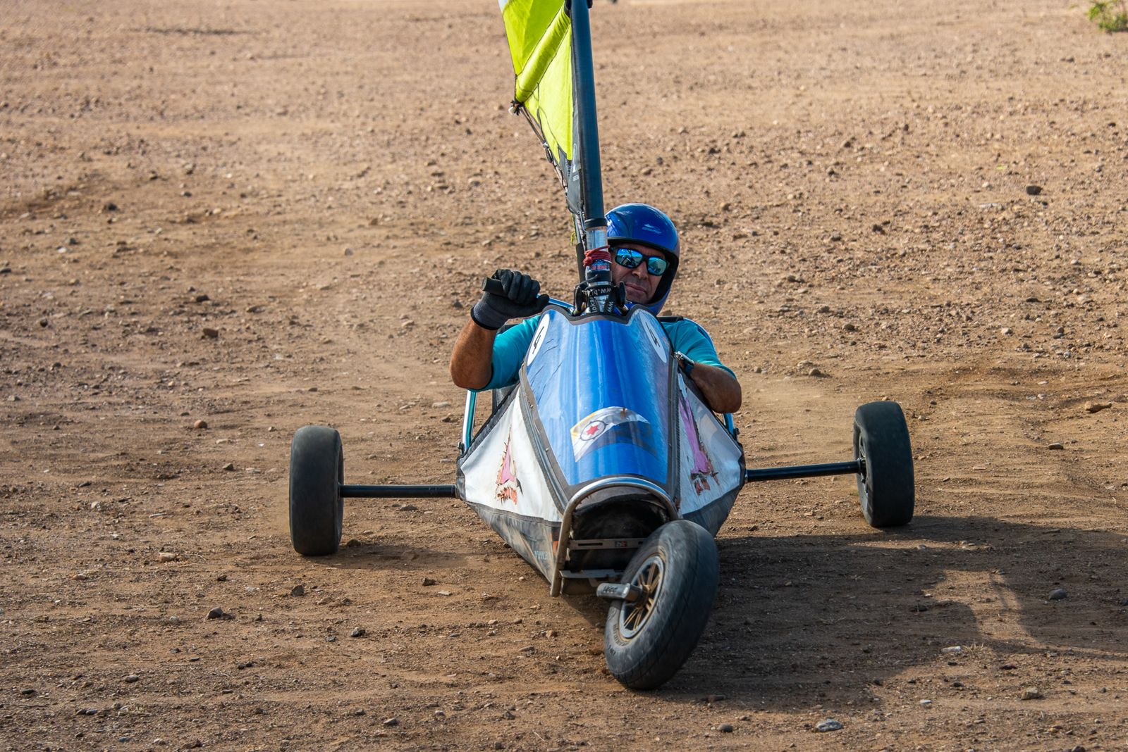A pilot in blue racing a blokart