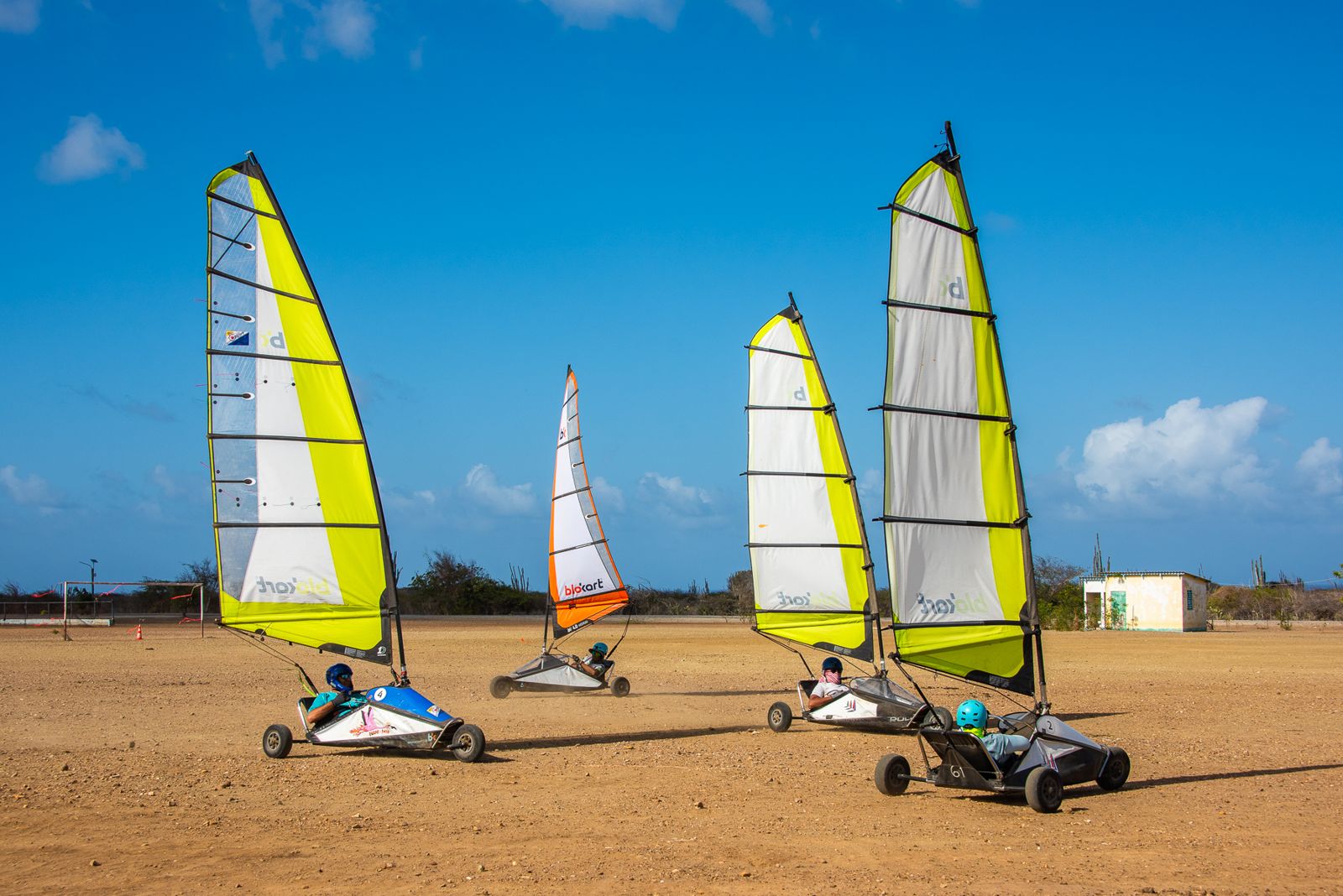 Three blokarts rigged under a blue sky