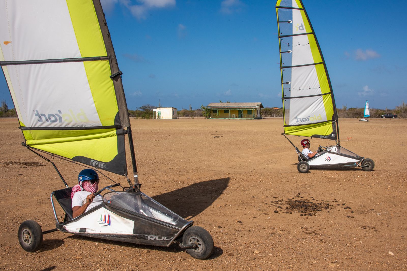 A yellow blokart sail against the blue sky